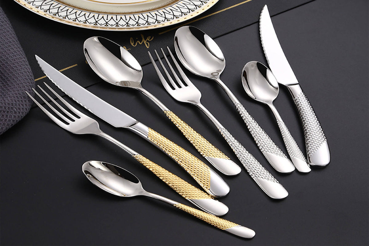 Elegant stainless steel flatware set with gold and silver textured handles, perfect for those exploring a flatware buying guide to find stylish and durable dining utensils.