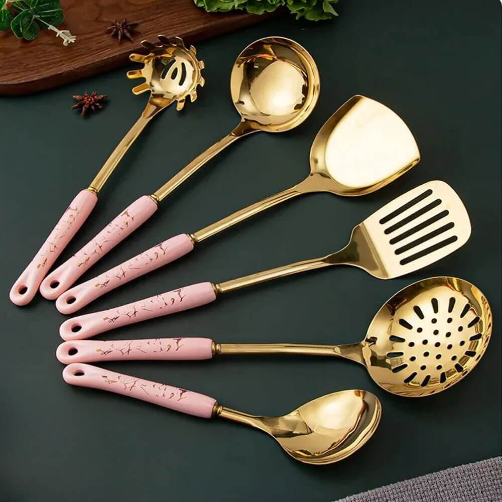 Set of six gold stainless steel kitchen utensils with pink marble-patterned handles, including ladles, spatulas, and slotted spoons.