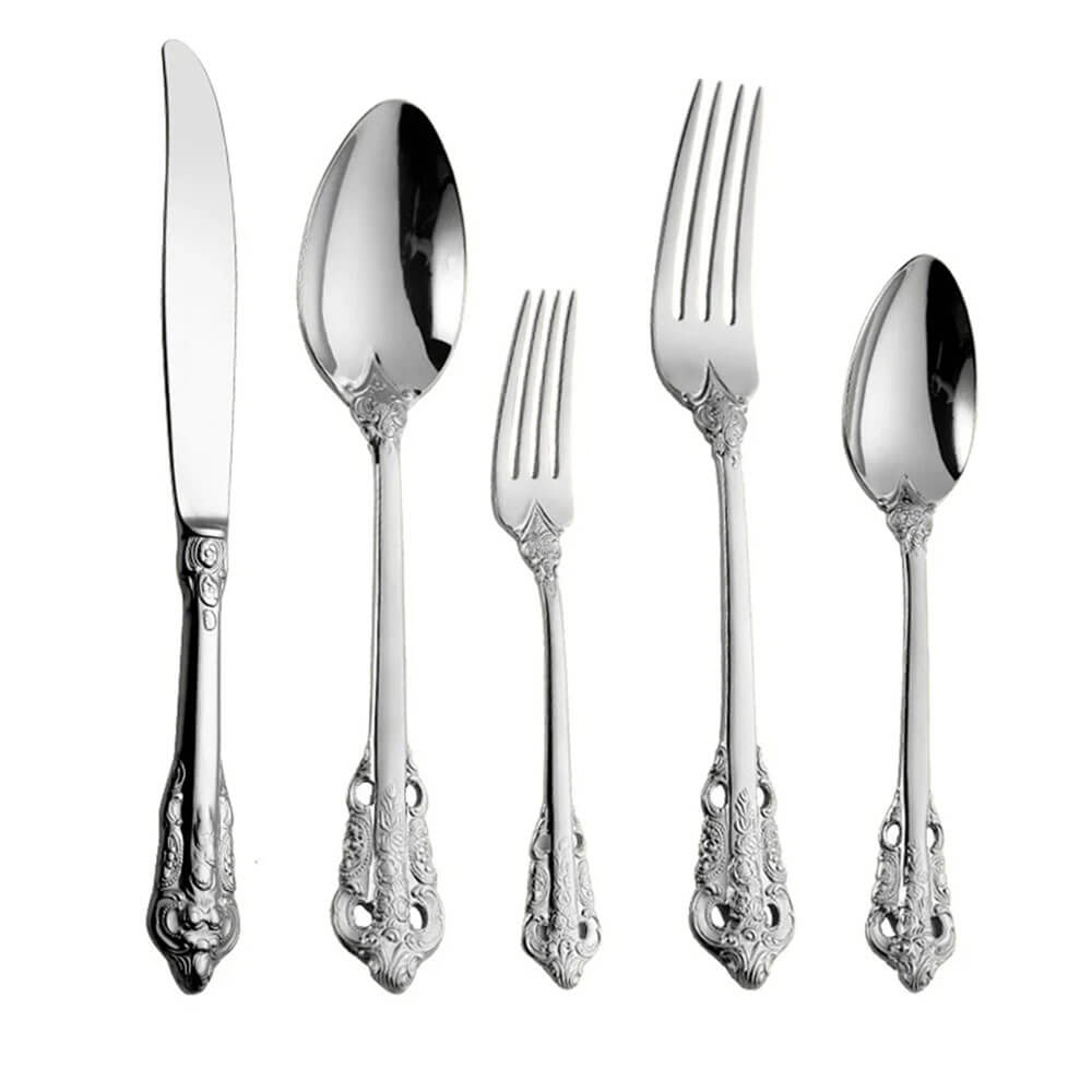 Five stainless steel utensils: knife, tablespoon, salad fork, dinner fork, and teaspoon. Each has an ornate, embossed handle design.