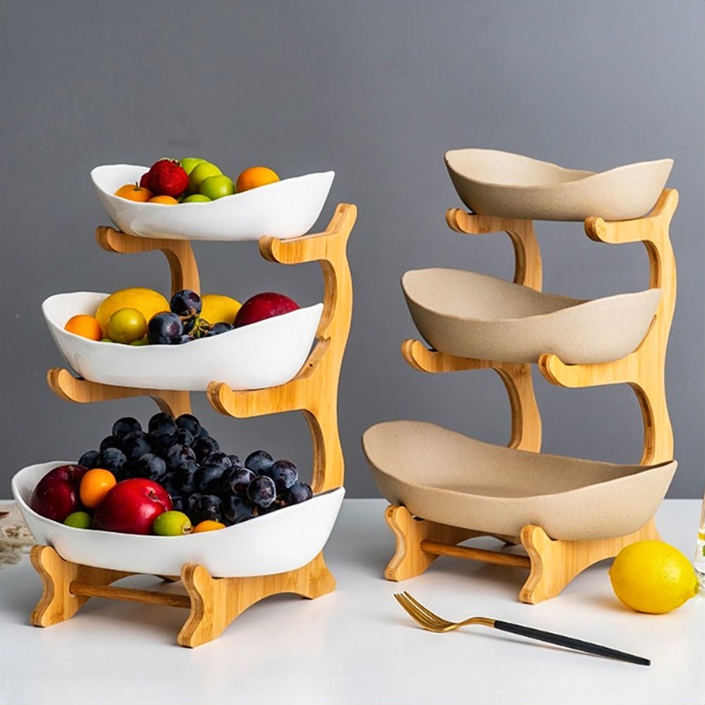 3-tiered fruit bowl set with bamboo stand and curved ceramic bowls, holding assorted fruits like grapes, apples, and citrus.