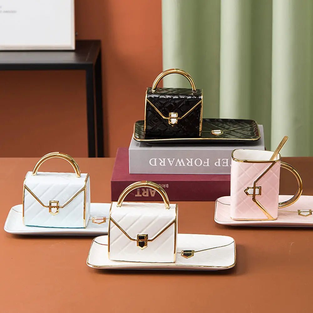 Collection of bag shaped coffee mug sets in black, white, and pink with gold handles, each placed on matching saucers.