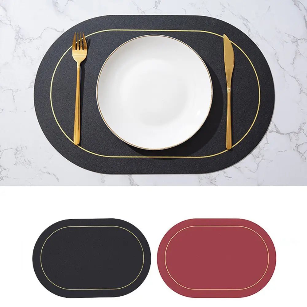 Black faux leather placemats with gold trim, reversible to burgundy, shown on a marble table set with a white plate and gold cutlery.