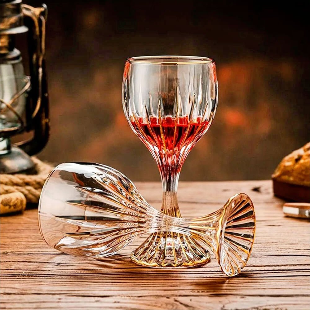 Elegant cocktail goblet glass with gold accents, perfect for wine, cocktails, and special occasions, displayed on wooden table.