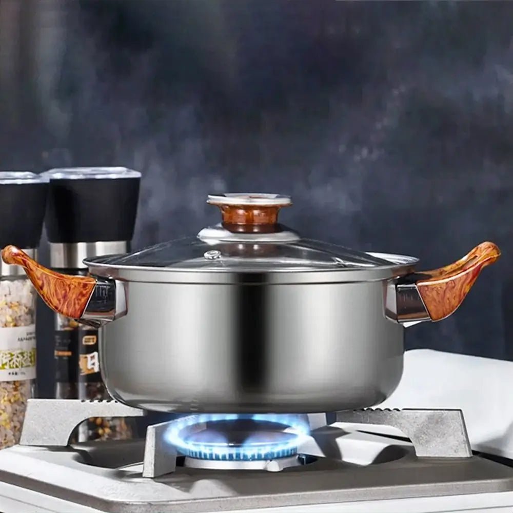 Cookware set stainless steel pot with wooden handles and glass lid heating on gas stove, kitchen background view.