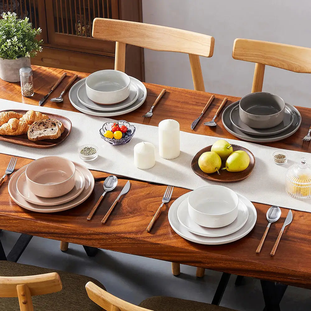 Dinnerware sets stoneware arranged on a wooden dining table with matching plates, bowls, and place settings for everyday dining.