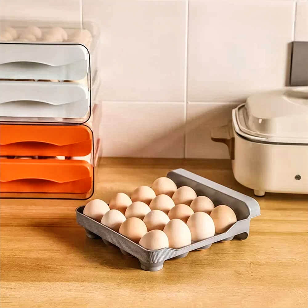 Gray egg container fridge tray with brown eggs on kitchen counter near stacked orange and white drawers for fridge organization.