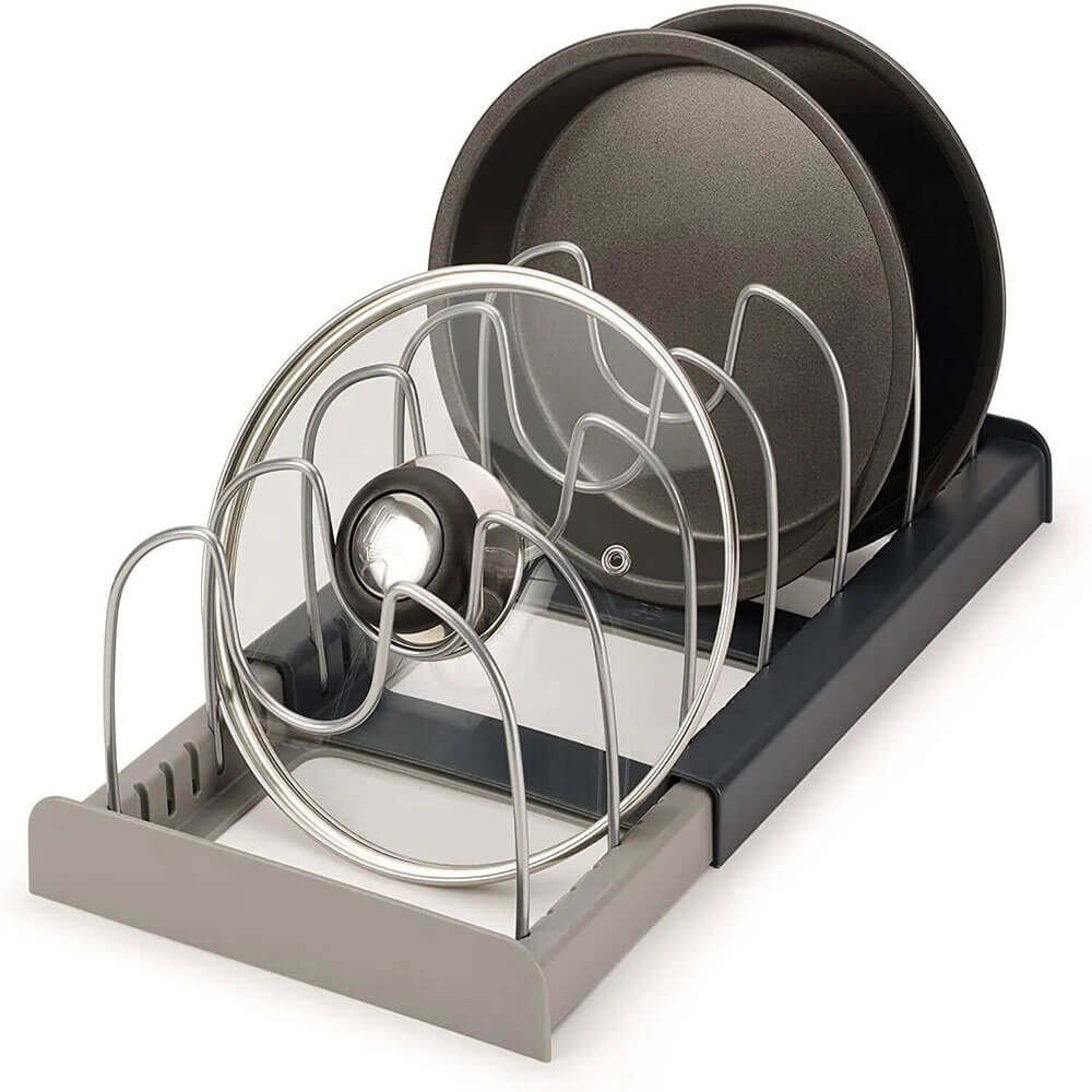 A compact and efficient expandable pot and pan organizer rack holding a glass lid and two pans. The adjustable metal dividers keep cookware upright and neatly organized, making it easy to access and store pots, pans, and lids in a space-saving manner.