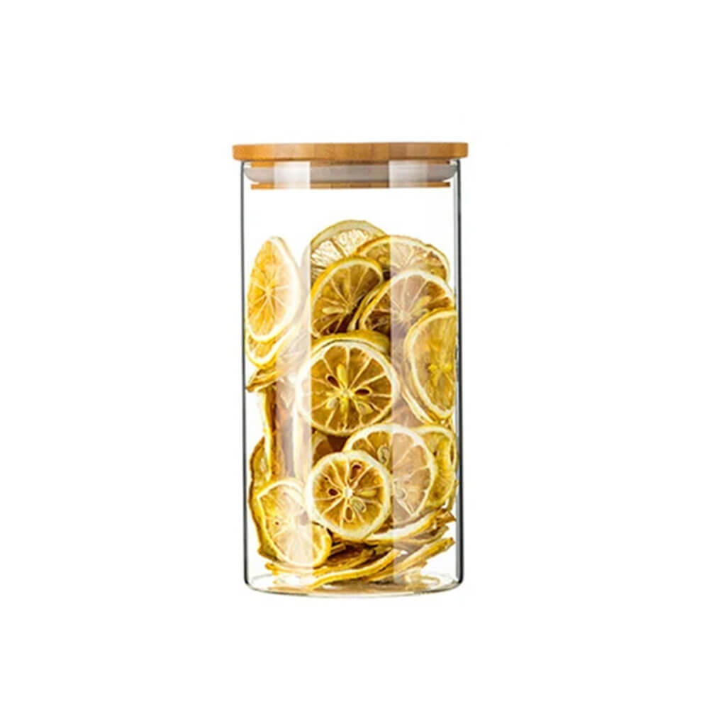 A tall cylindrical glass and bamboo jar filled with dried lemon slices, featuring a flat bamboo lid with a silicone gasket for an airtight seal.