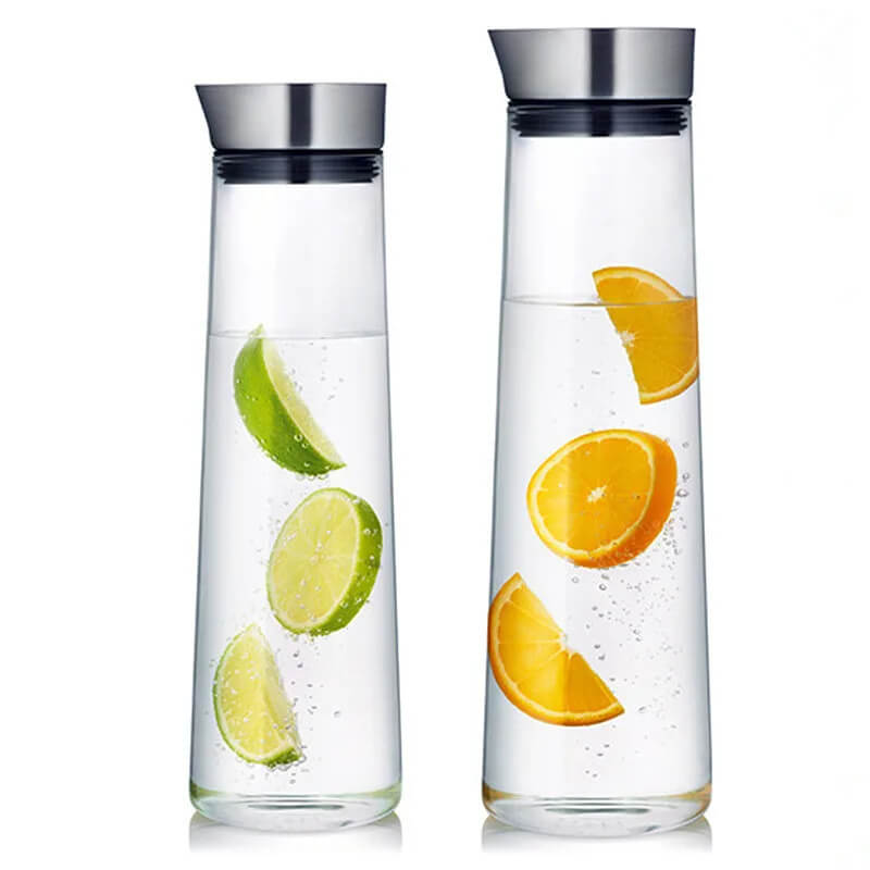 Two tall bottles of glass bottled water, each with a stainless steel leakproof lid. One is infused with lime slices, the other with orange slices. Both have a clear, tapered design ideal for serving flavored water.