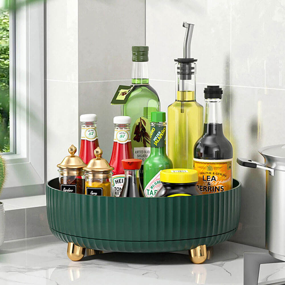 Lazy susan corner cabinet holds sauces, oils, and spices, offering organized storage with a green base and gold feet.