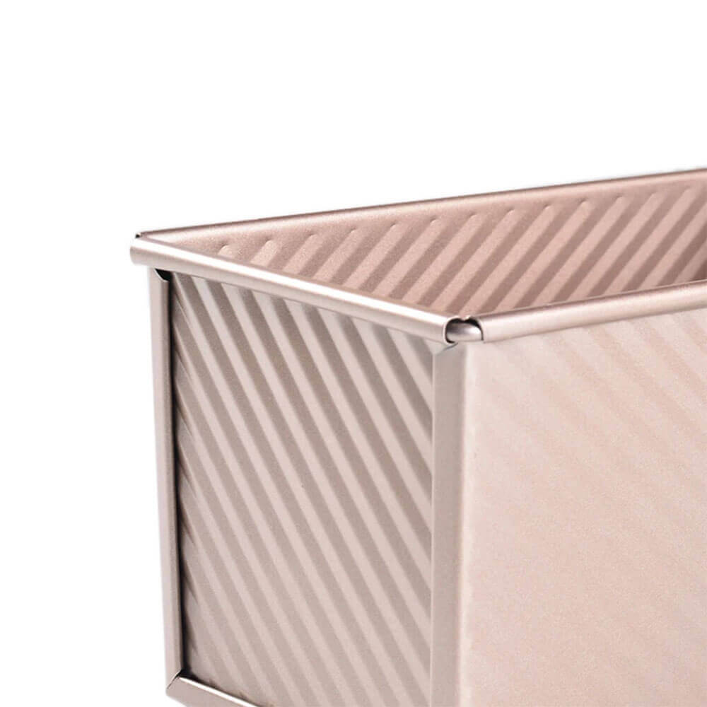 Close-up of a textured non-stick loaf pan with a metallic finish, ideal for baking bread.