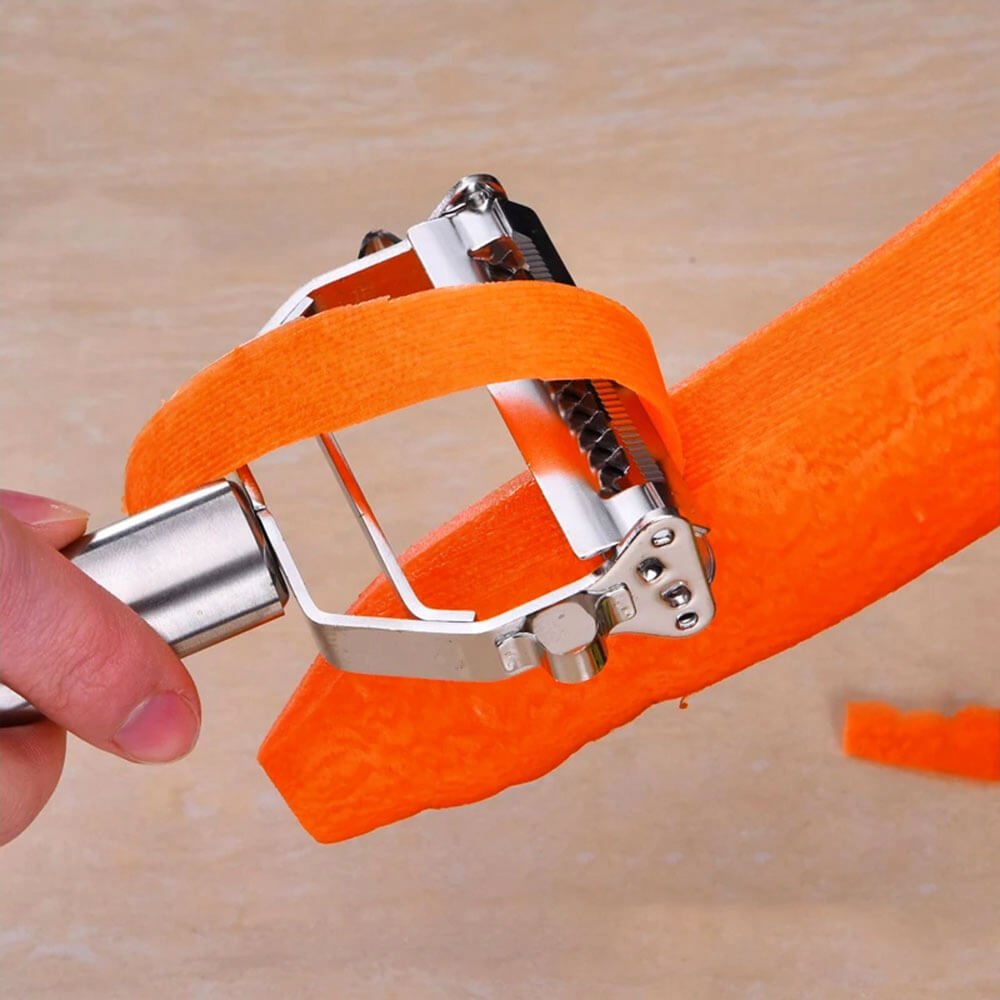 Stainless steel peeler being used to peel a carrot, creating thin, even strips. Ideal for peeling vegetables with precision and efficiency.
