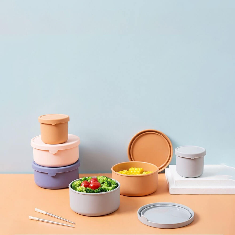Assorted silicone storage containers filled with vegetables and corn, ideal for reusable, leakproof, and stackable food storage.