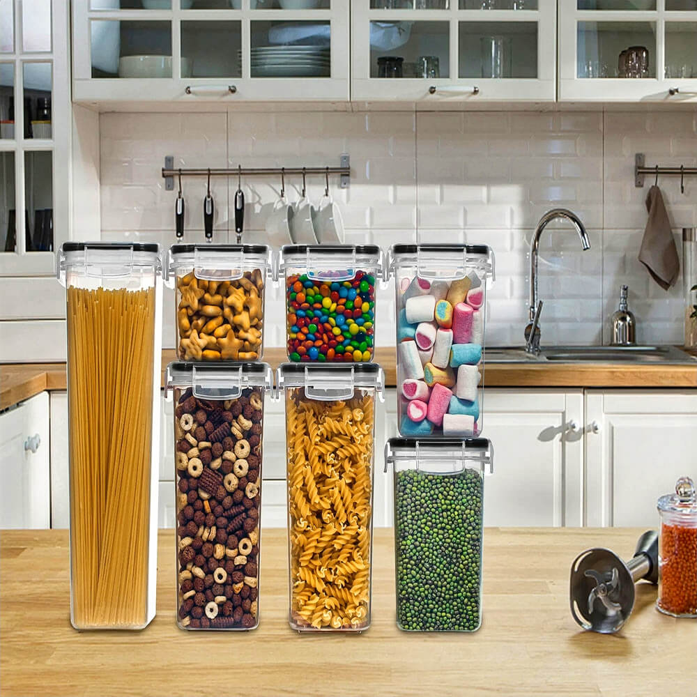 Stackable containers for pantry filled with pasta, cereal, candy, marshmallows, and peas, organized on a kitchen counter.