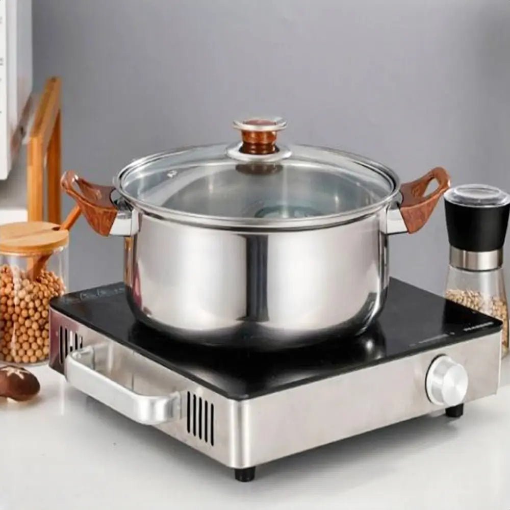 Stainless steel cookware sets on sale featuring pot with glass lid and wood handles on electric stovetop in kitchen.