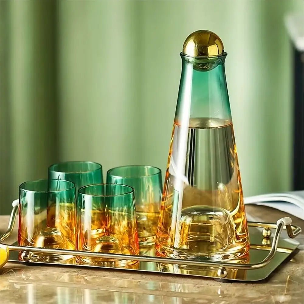 Glass water carafe and glass set on a gold tray, featuring a green and amber gradient carafe with a gold ball lid and four matching glasses.
