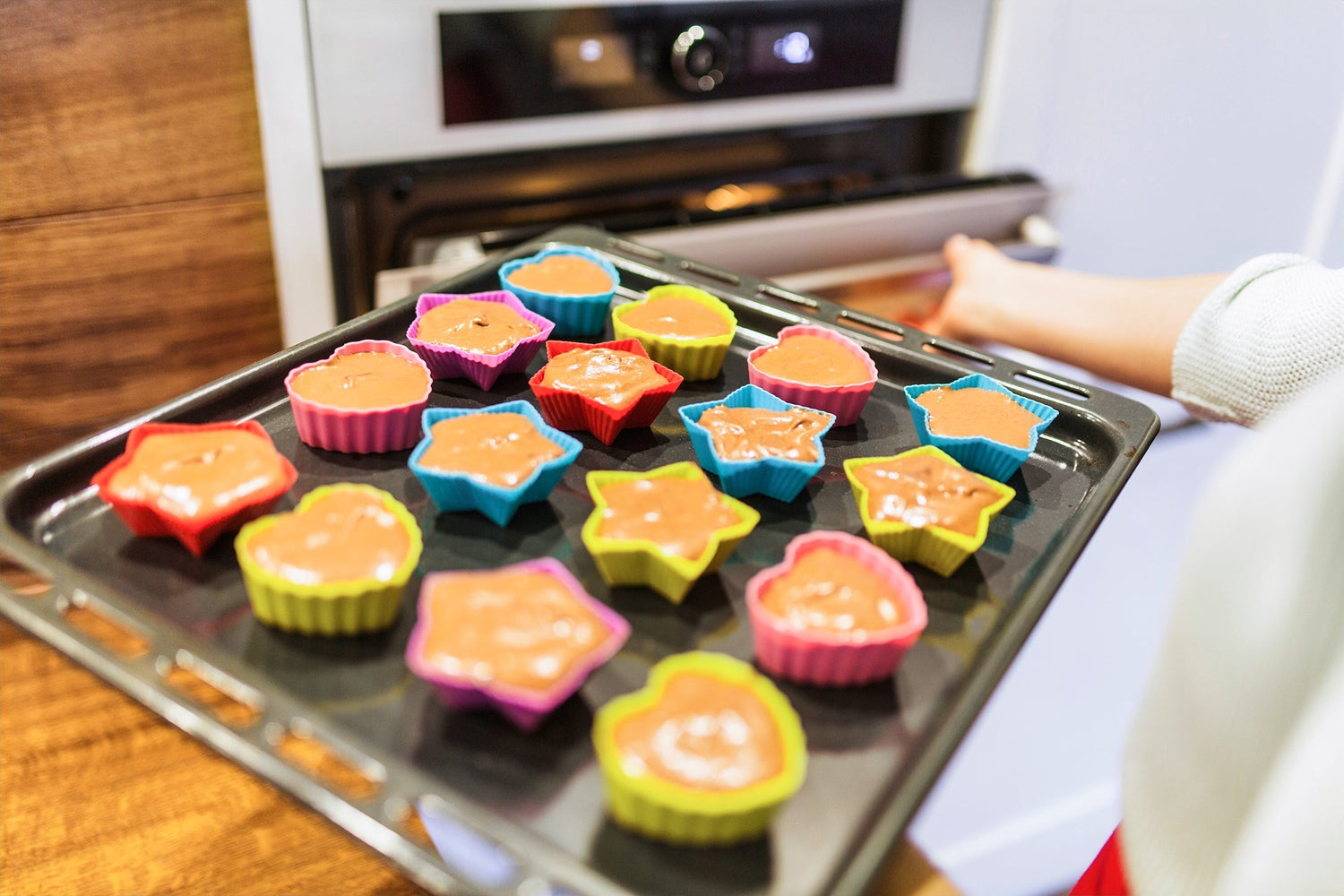 Silicone cupcake cake mold with a woman carrying a cupcake tray, showcasing the mold's flexible, non-stick material and its ease of use for baking cupcakes.