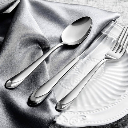 A flatware set crafted from 18/10 stainless steel, featuring a polished mirror finish. The set includes a spoon, knife, and fork with tapered, smooth handles, displayed on a silver fabric and a white textured decorative plate in the background.