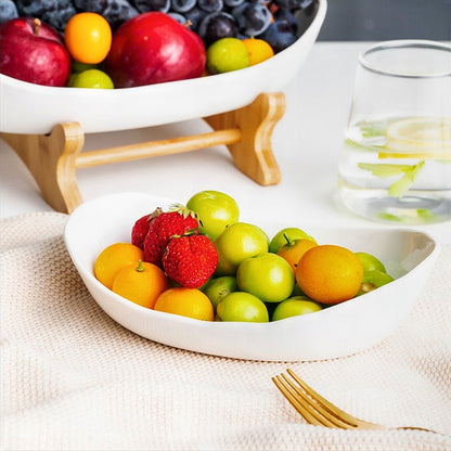 A white 2-tiered fruit bowl filled with a colorful assortment of fresh fruits, showcasing a practical and elegant way to organize and display produce on your countertop.