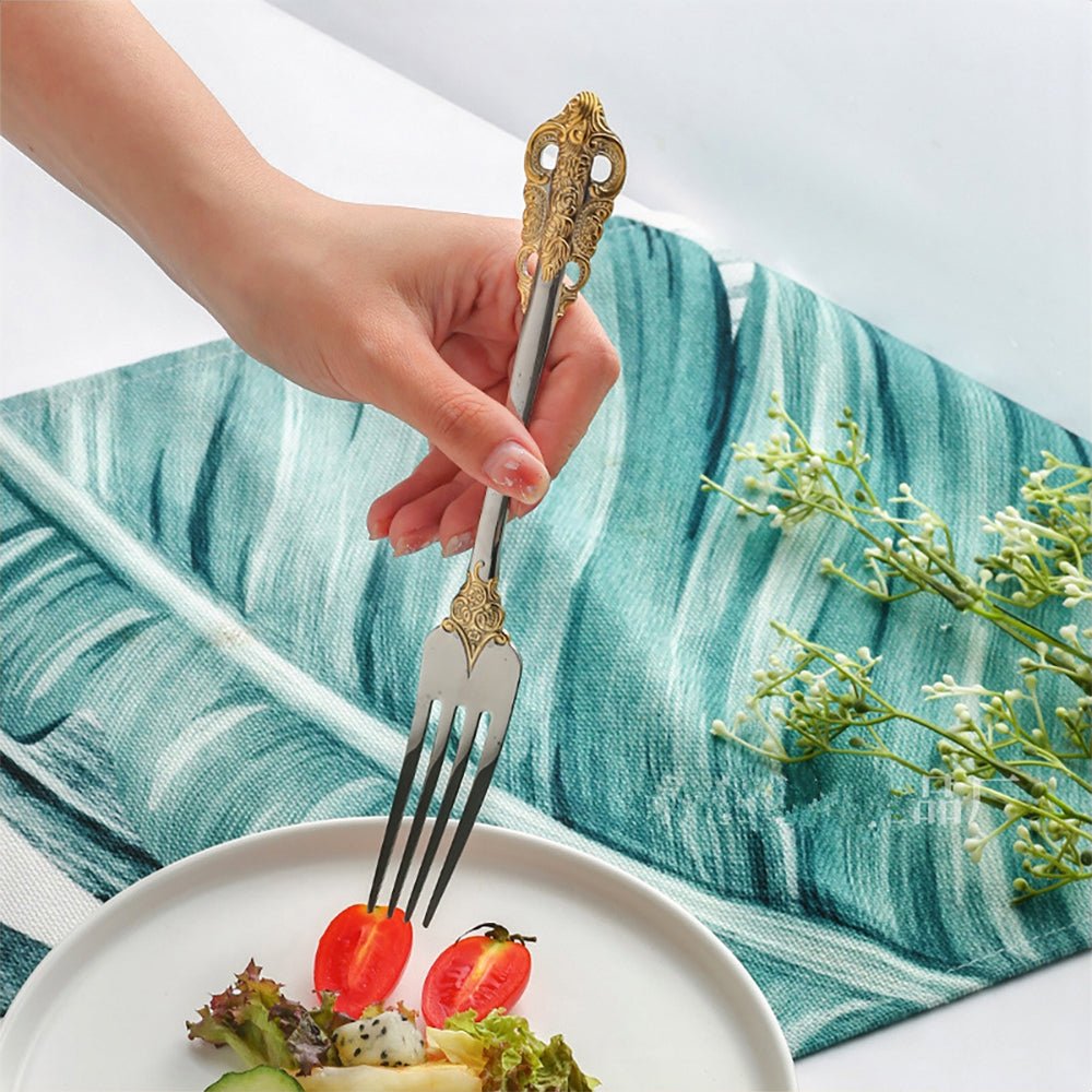 A woman using a fork from a 20-piece stainless steel flatware set to eat a tomato.