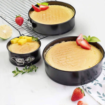 6 inch springform cake pan set with baked cheesecake topped with strawberries and mango cubes.