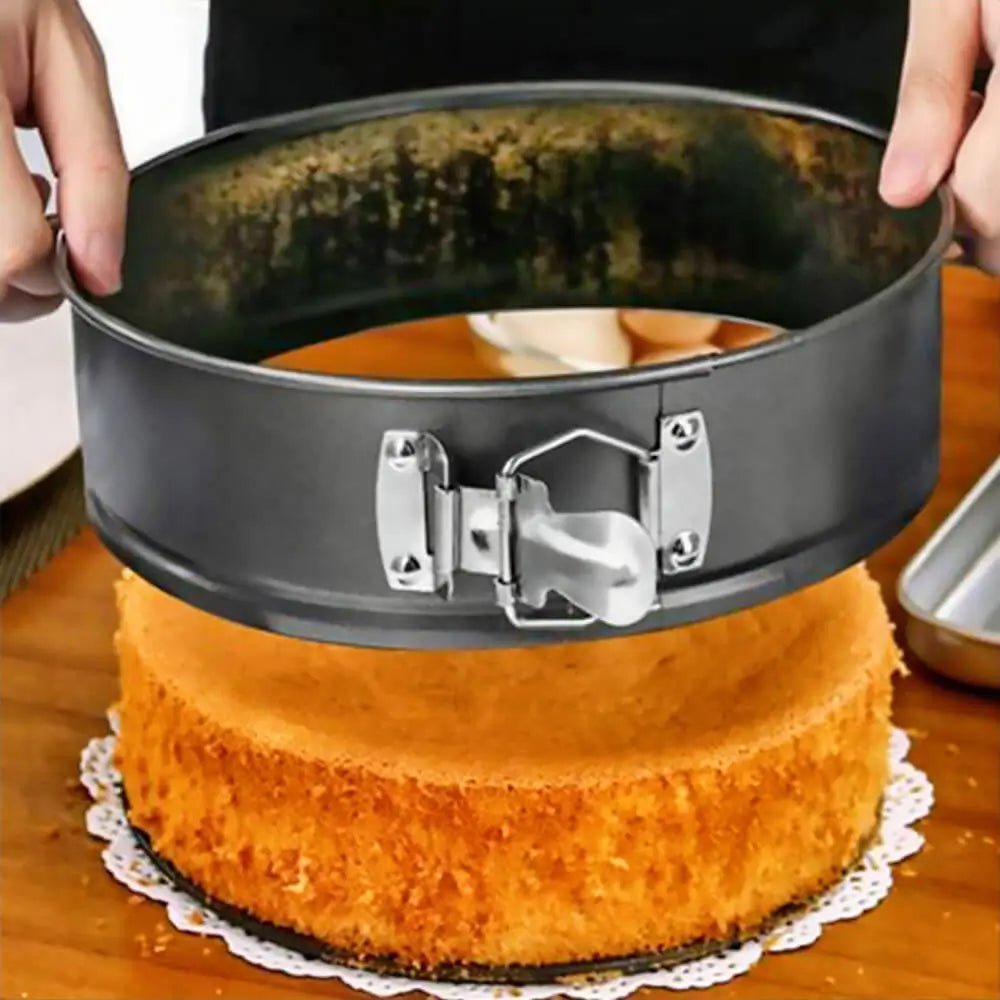 Cake being removed from a springform pan on a wooden surface.