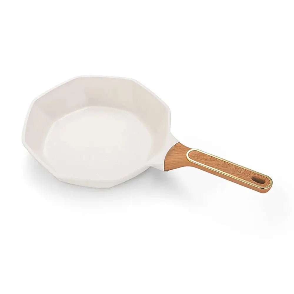 Small white frying pan with a wooden handle on a white background