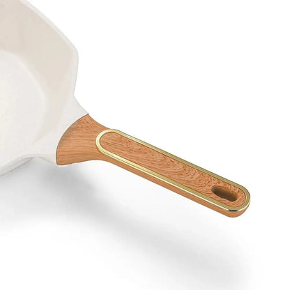 White frying pan with a wooden handle on a white background