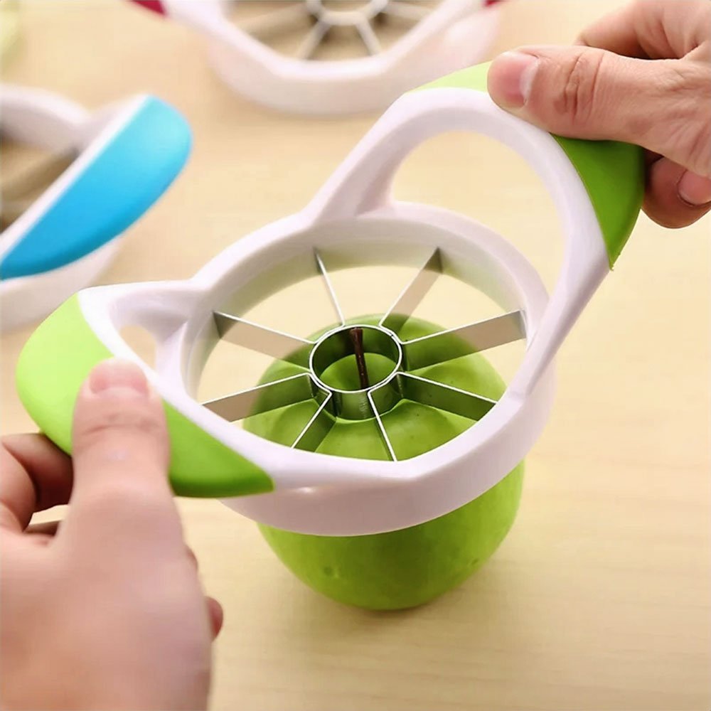 A stainless steel apple peeler corer slicer cutting a fresh green apple into eight even slices, removing the core with ease.