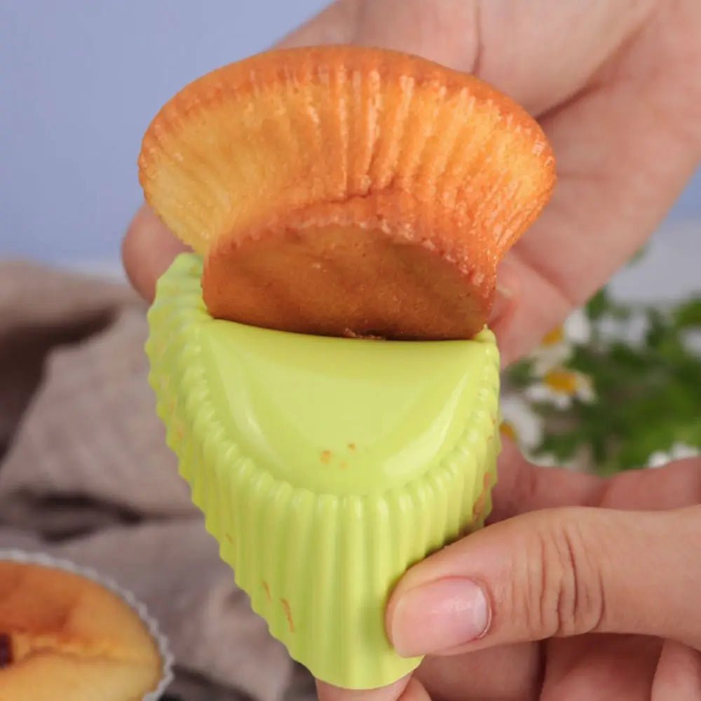 Baking with silicone baking cups as a muffin is removed from a flexible green cup by hand, showing easy release and nonstick performance.