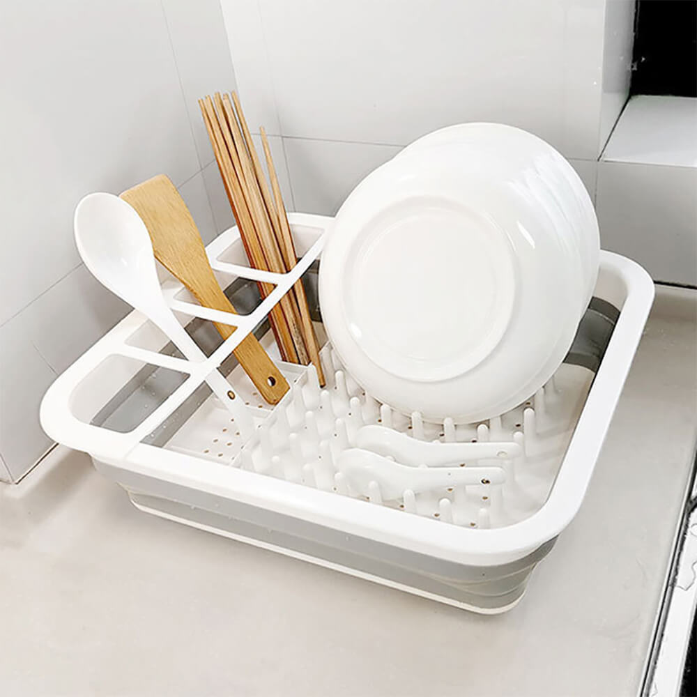 Best collapsible dish rack with a sleek white and gray design, holding plates, utensils, and wooden spoons, ideal for compact and efficient dish drying.