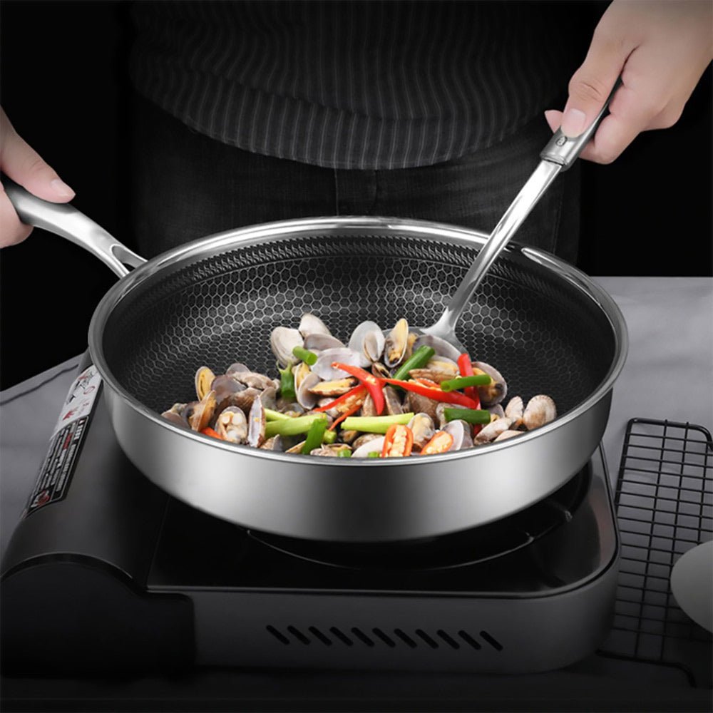 A woman cooks with the best honeycomb frying pan featuring stainless steel, a stay-cool handle, and a nonstick surface.