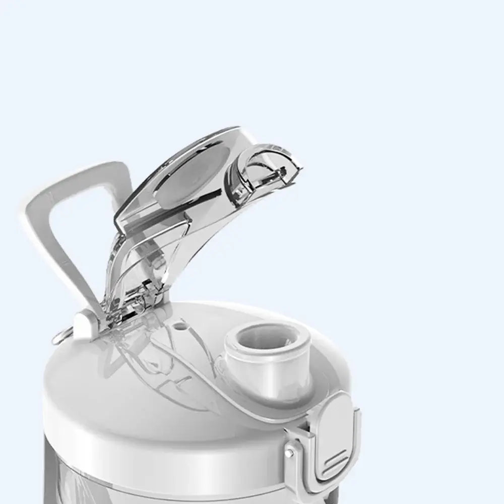 Close-up of a white portable blender with a lid on a light gray background.
