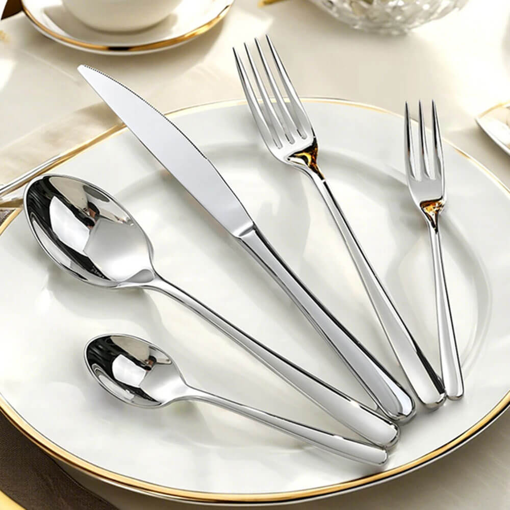 Best-silverware-sets displayed on a white plate with gold rim, featuring polished stainless steel forks, knives, and spoons.