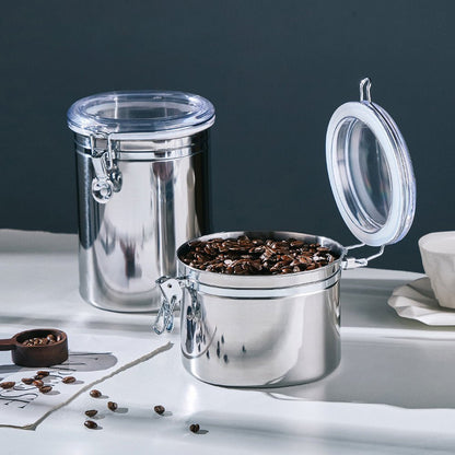 The best stainless steel food storage containers have airtight seals and clear lids. An open container with coffee beans is on display.