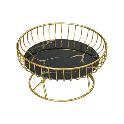 A stylish black pedestal fruit bowl featuring a sleek round black marble base with gold vein detailing and a surrounding gold metal wire frame for a modern and elegant design.