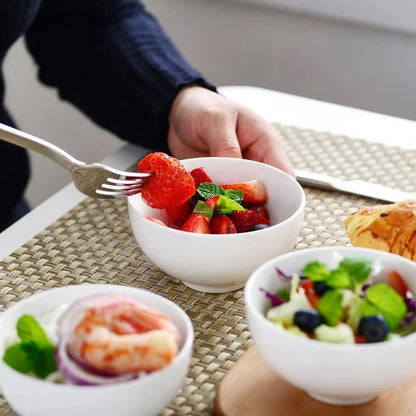 Two bowls of snacks: one filled with fresh strawberries, the other with a mixed salad.