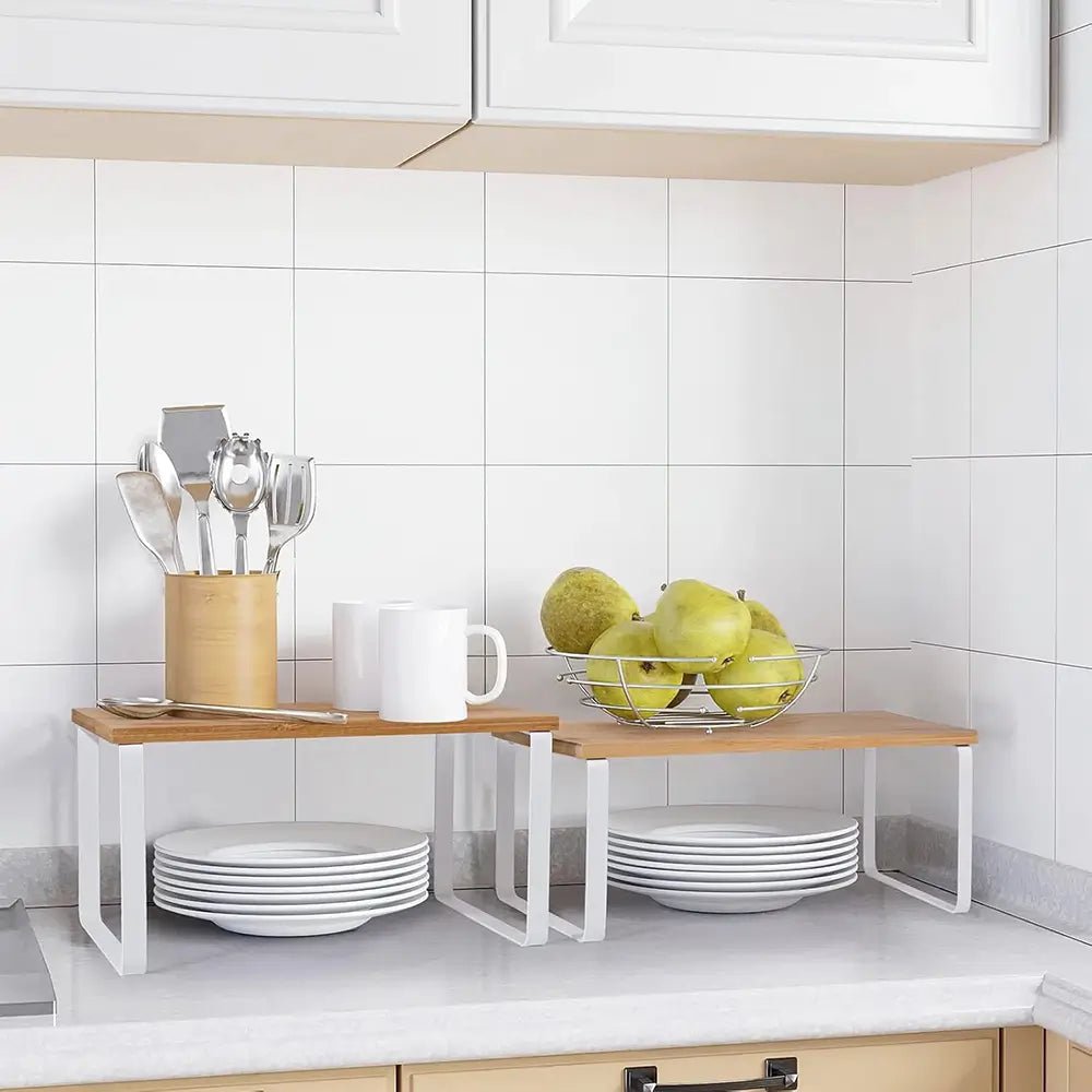Kitchen counter with a wooden shelf holding utensils, cups, and a fruit bowl.