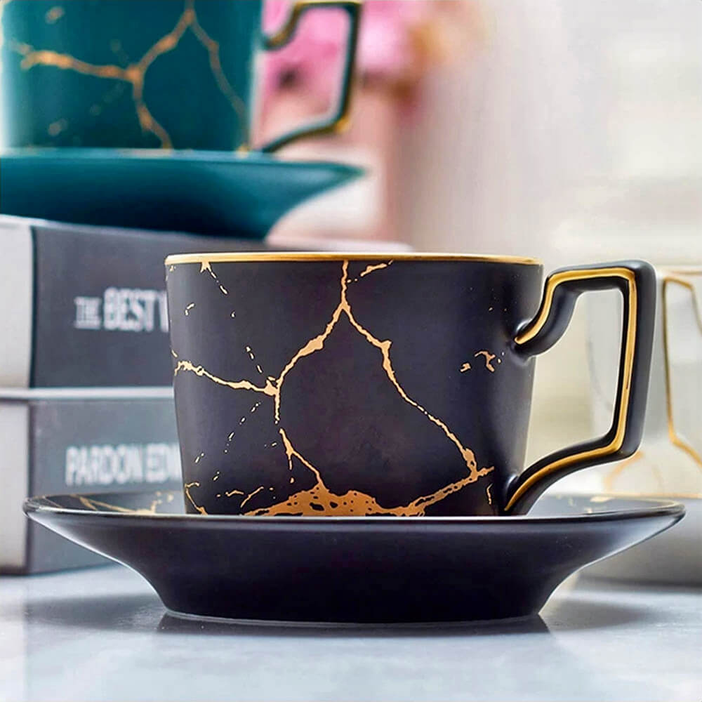 A luxurious cappuccino cup and saucer set with a glossy black finish, gold veining, and elegant detailing. Perfect for elevating your coffee experience.