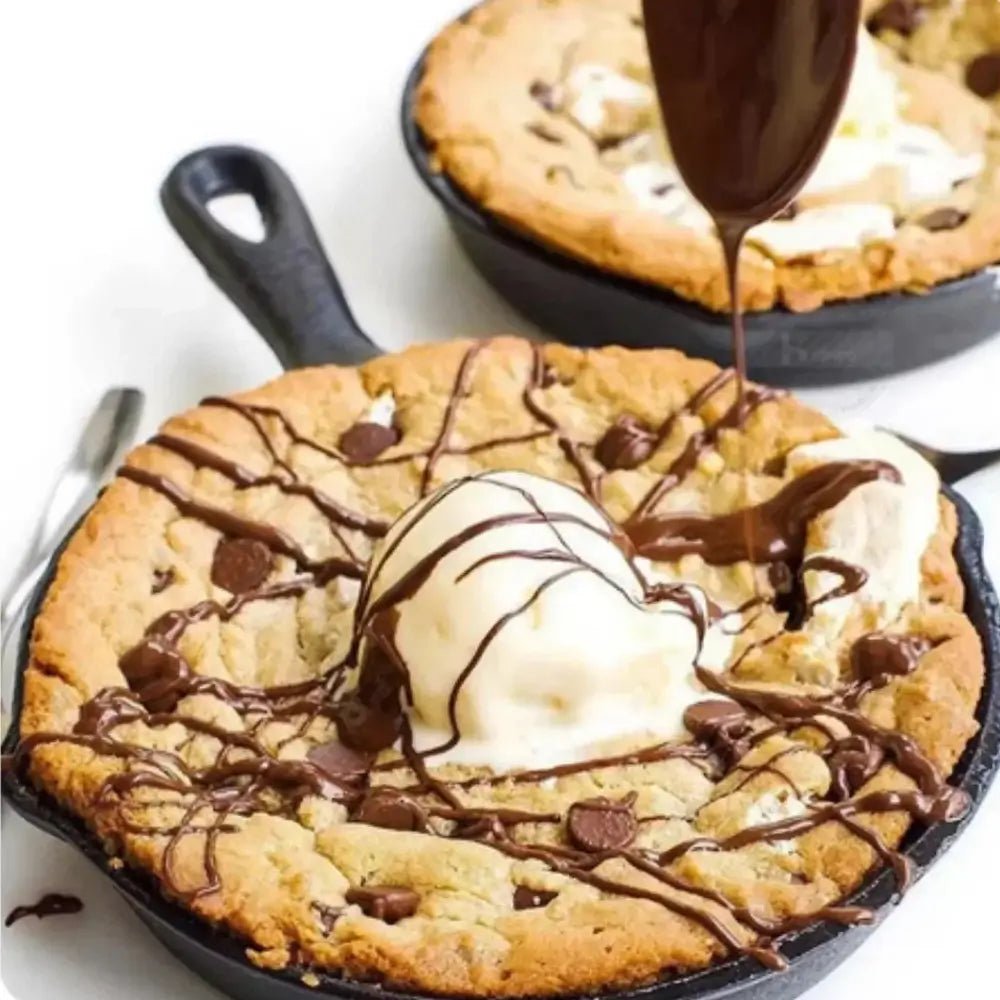 Skillet cookie with ice cream and chocolate drizzle on a white background
