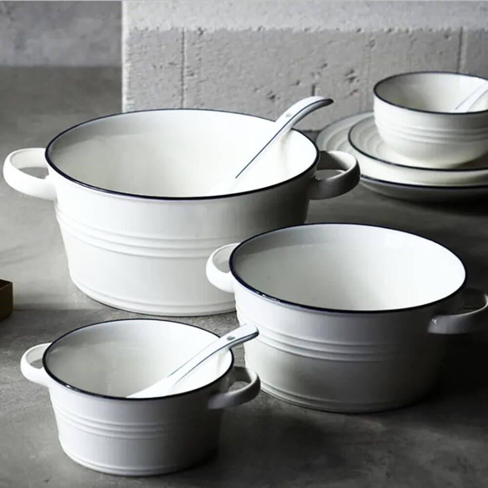 White ceramic stockpot with lid and handles, perfect for cooking soups, stews, and slow meals in a modern, stylish kitchen.