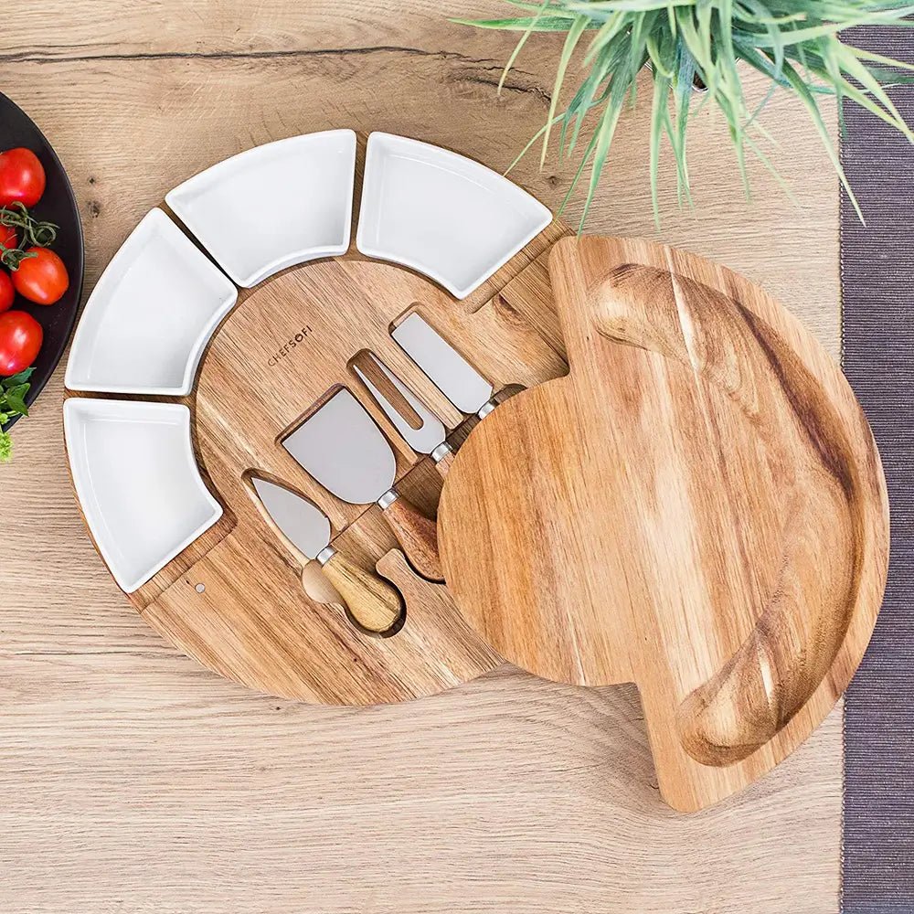 Wooden cheese board and knives gift set with four stainless steel cheese tools and four white ceramic serving bowls.