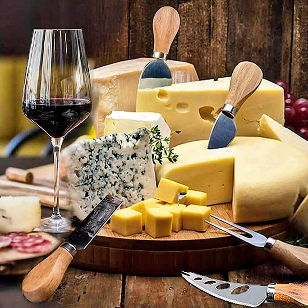 A beautifully arranged cheese board featuring a variety of cheeses, including blue cheese, Swiss cheese, and cheddar, accompanied by a glass of red wine. A cheese knives set with bamboo handles is displayed, including a fork, spreader, and slicing knives, perfectly suited for serving and cutting the cheeses. The rustic wooden table and warm lighting create an inviting atmosphere, ideal for entertaining or a cozy gathering.