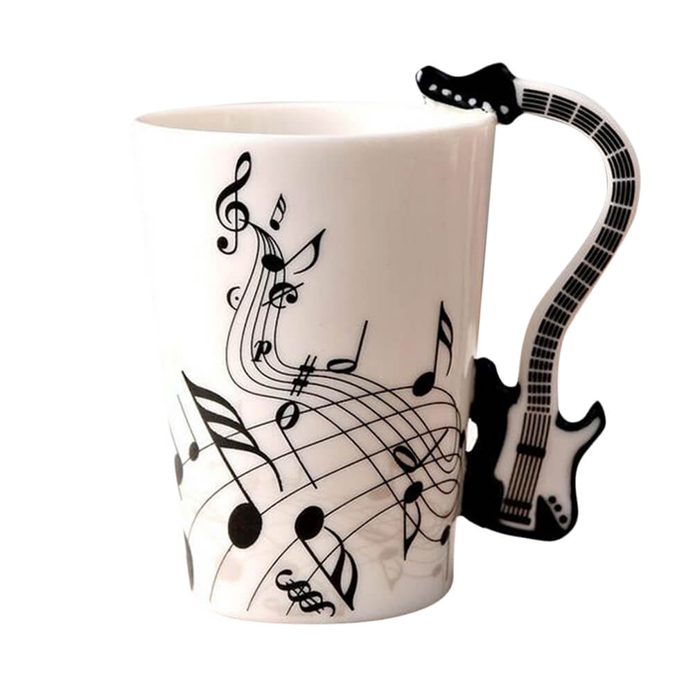 White coffee mug with guitar handle, decorated with black music notes and a black electric guitar shaped handle on the side.








