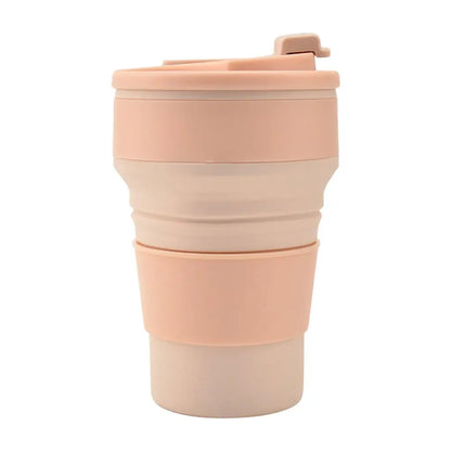 Collapsable tumbler in a folded design with lid and grip band, shown in a soft pink color on a white background.
