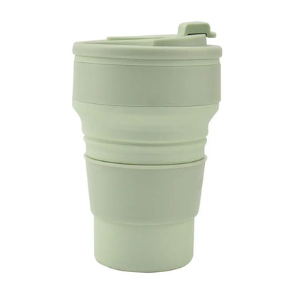 Collapsible travel tumbler in a folded design with lid, shown in a light green color on a white background.