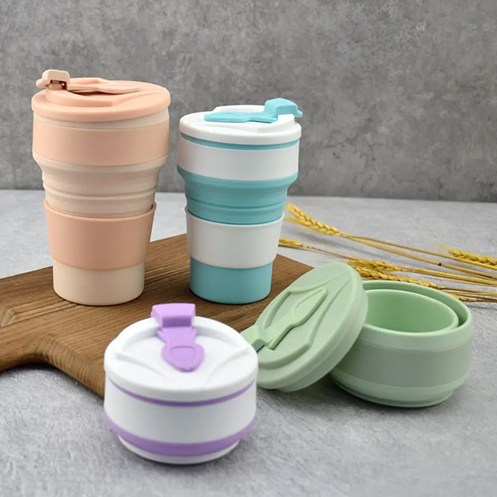 Collapsible tumbler with lid shown in multiple pastel colors, including folded and expanded designs on a tabletop display.