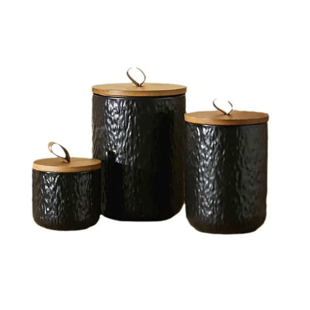 Set of three black hammered ceramic condiment containers with natural wood lids, designed for stylish and functional kitchen storage.