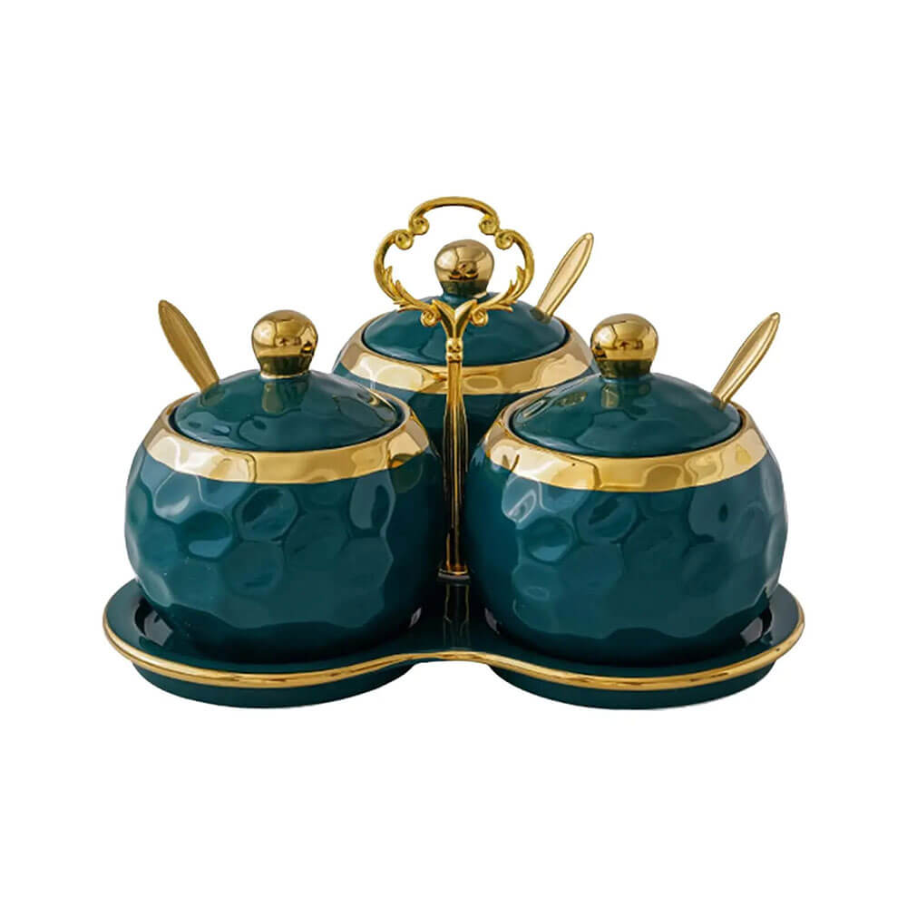 Three-piece condiment container set with gold-accented lids, matching spoons, and a coordinated tray with handle.