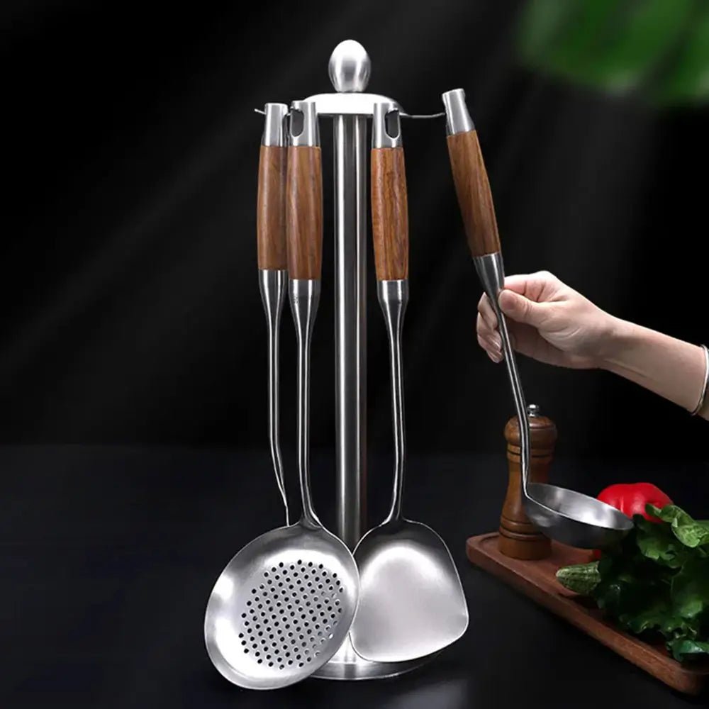 Stainless steel cooking utensils with wooden handles on a metal stand, including ladle, skimmer, and spatula.